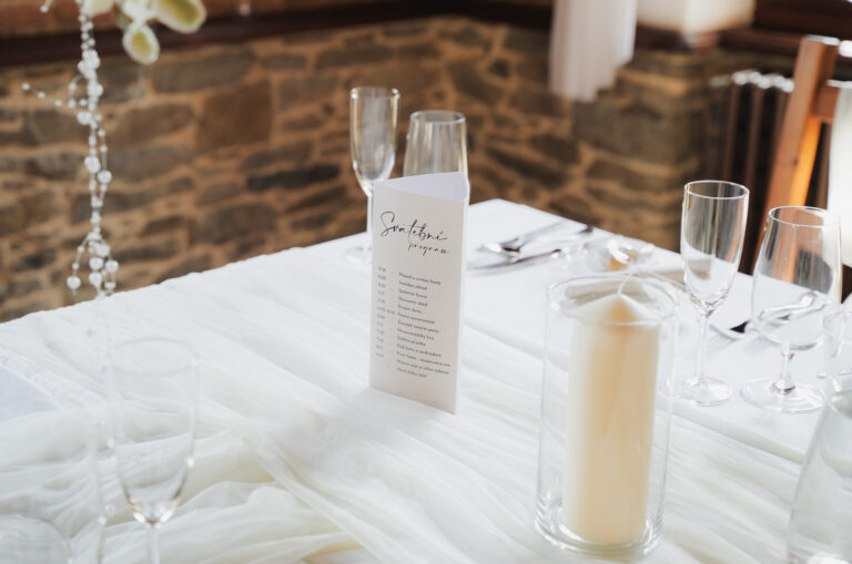 Detail prostírání s menu a svíčkami
