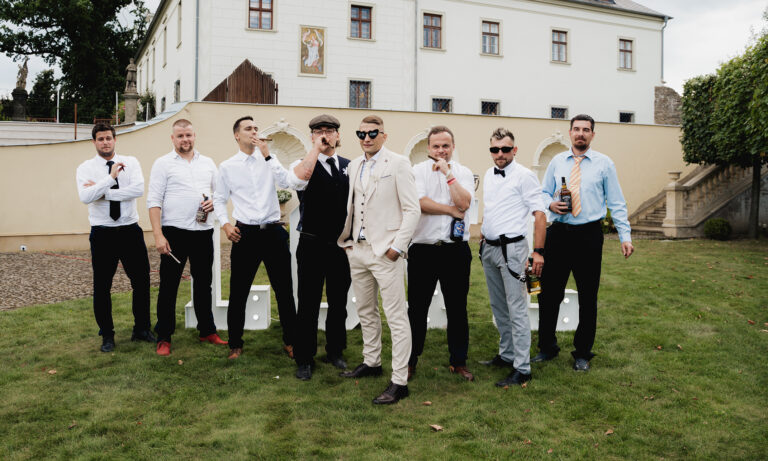 Svědci a hosté pózují před zámkem