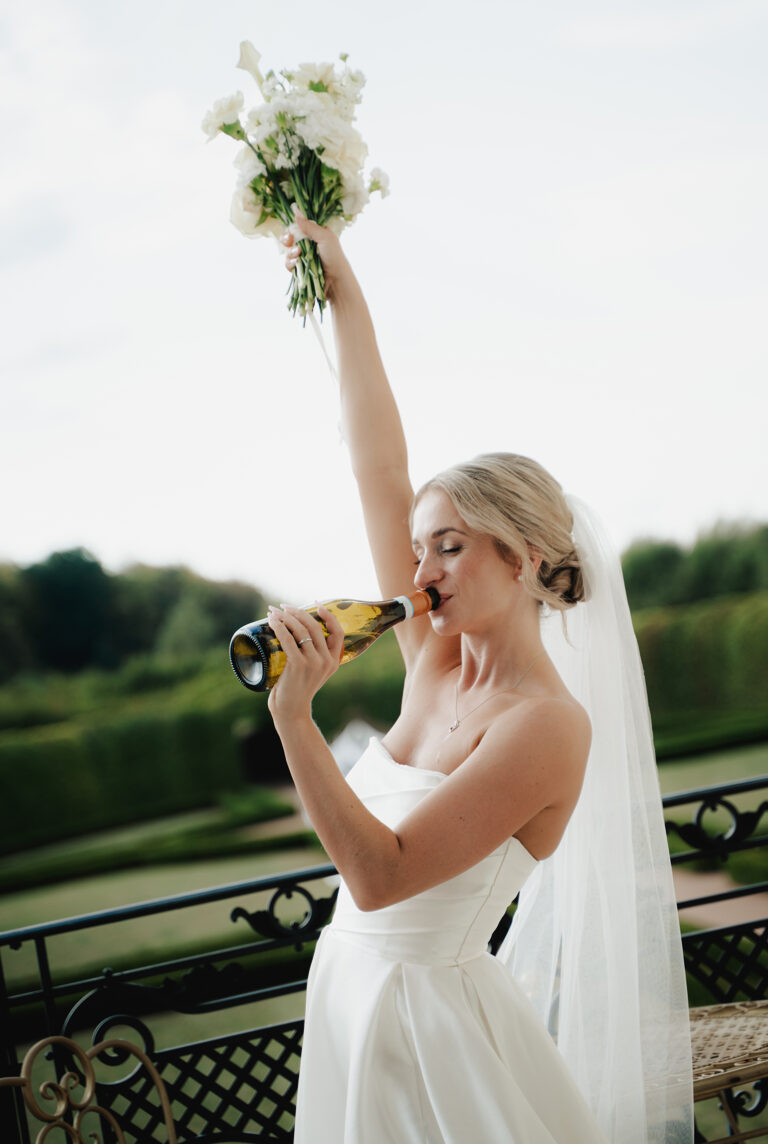 Nevěsta pije sekt z lahve na balkoně